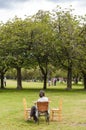 Woman seated at a table, relaxing in a park in the centre of Edinburgh